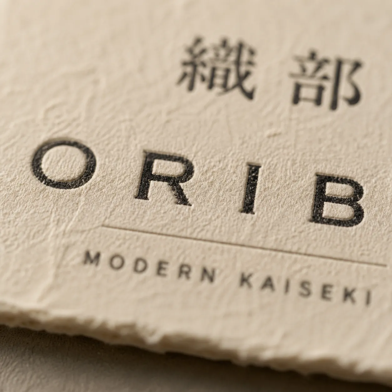 ORIBE wordmark debossing detail — serif signature on cream washi paper